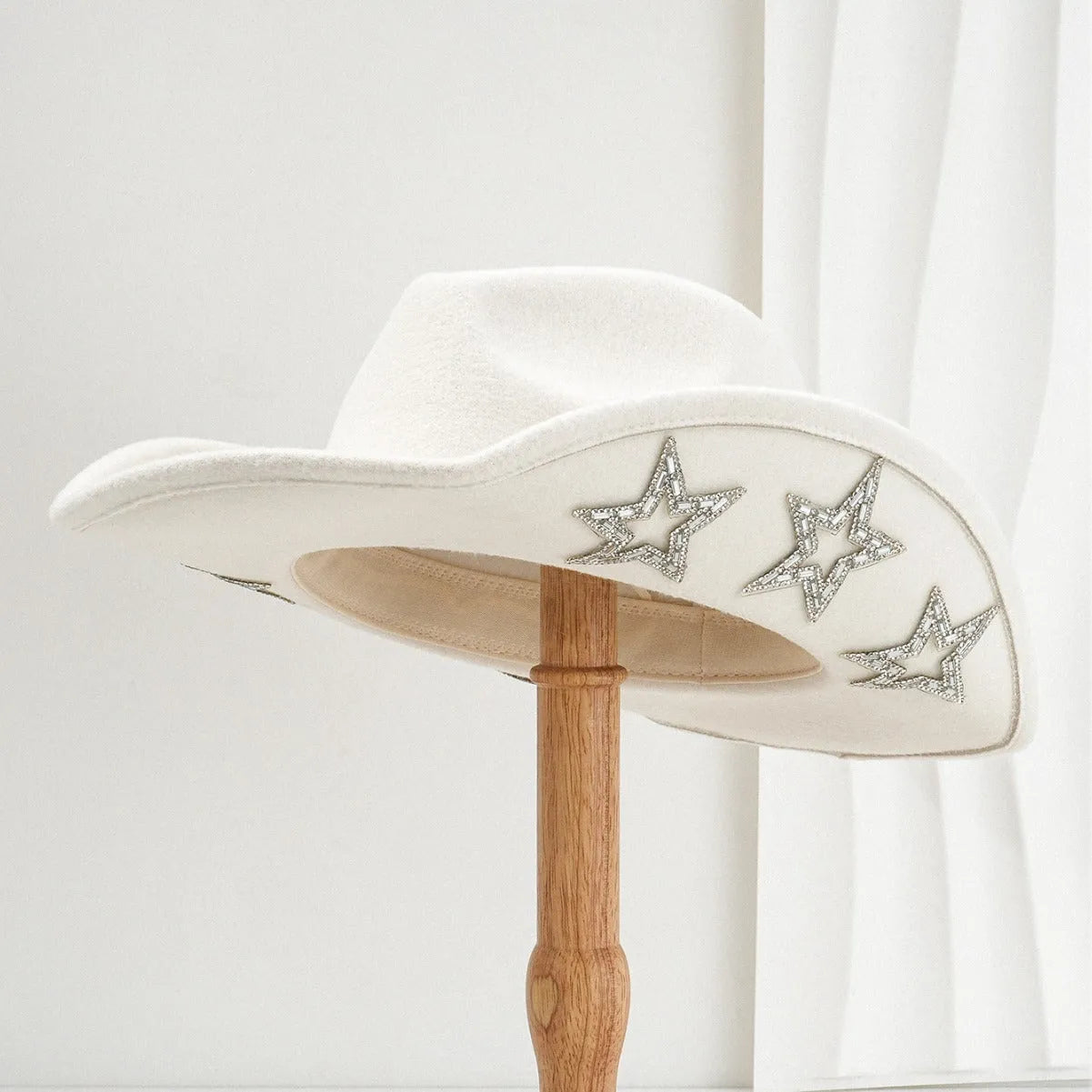 Beige polyester Western top hat with a conical crown and a silver hexagonal star decoration on the front.