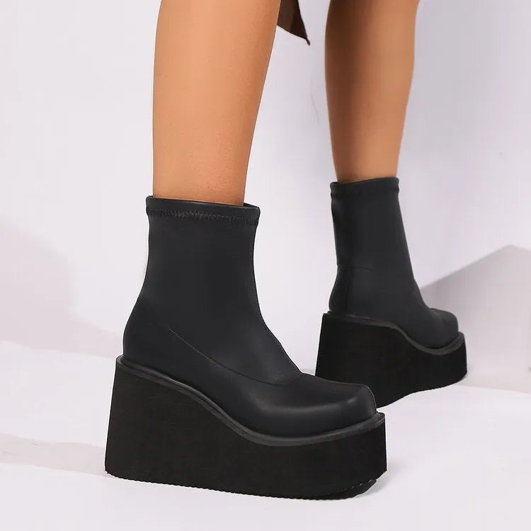 Plus size women's black wedge heel boots with a waterproof platform on a white background.