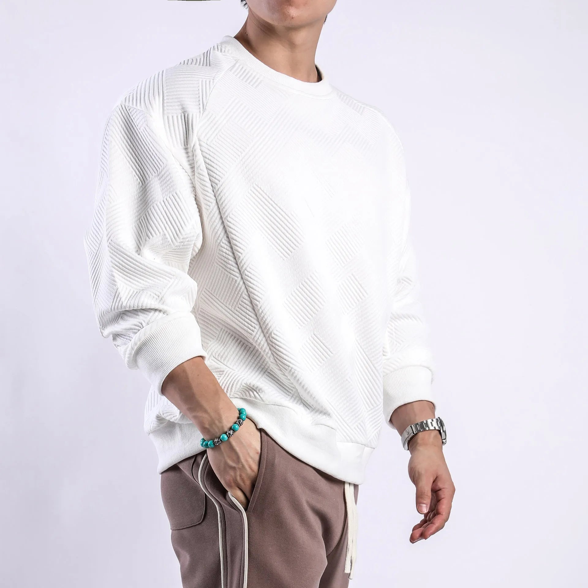 Man wearing a loose fit Army Green twill jacquard long sleeve pullover sweater.