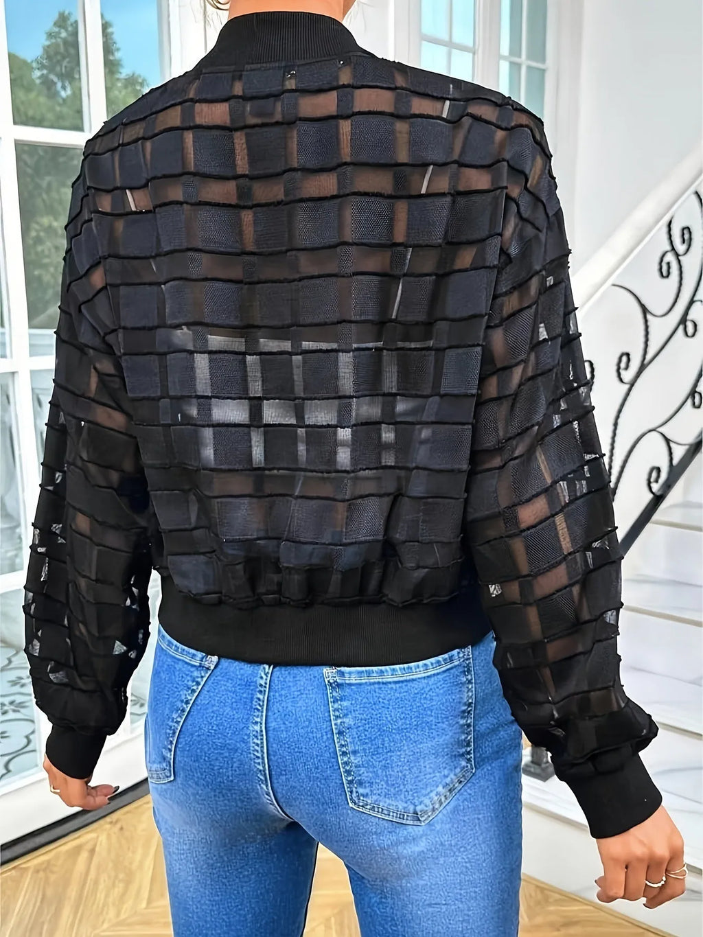 Black women's jacket with geometric pattern and semi-transparent polyester fabric showing zipper closure
