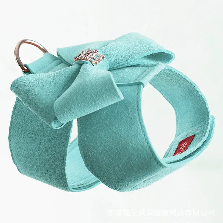 A pink microfiber puppy chest strap harness with a large bowknot, shown on a small dog.