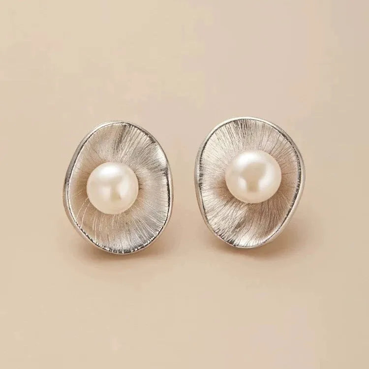 A pair of gold-coloured geometric sterling silver ear studs featuring pearl accents.