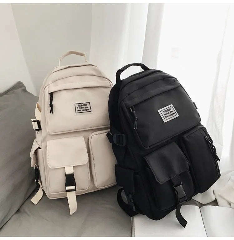Black and white nylon student backpack with laptop compartment and three-dimensional outer pockets.
