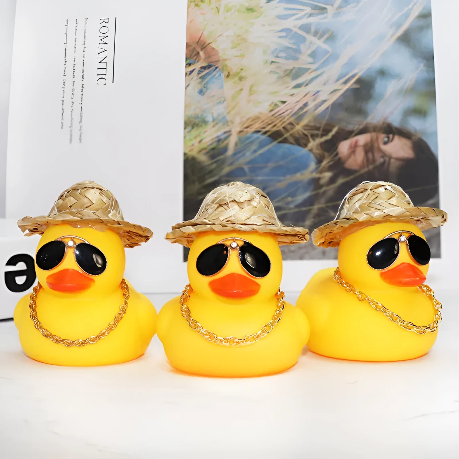 Cartoon yellow duck wearing a straw hat car dashboard ornament on a matte yellow base.