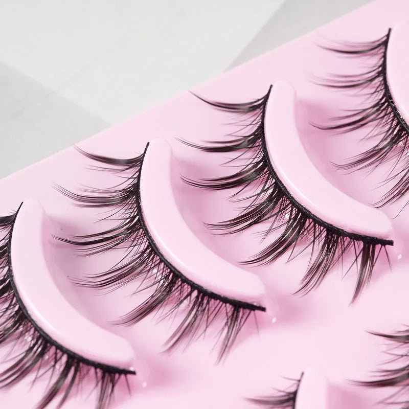 5 pairs of manga-style false eyelashes on a black strip, showing natural wispy Korean makeup look.