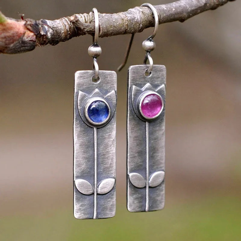 A pair of antique finish red sapphire geometric drop earrings with an elliptical design in a retro style