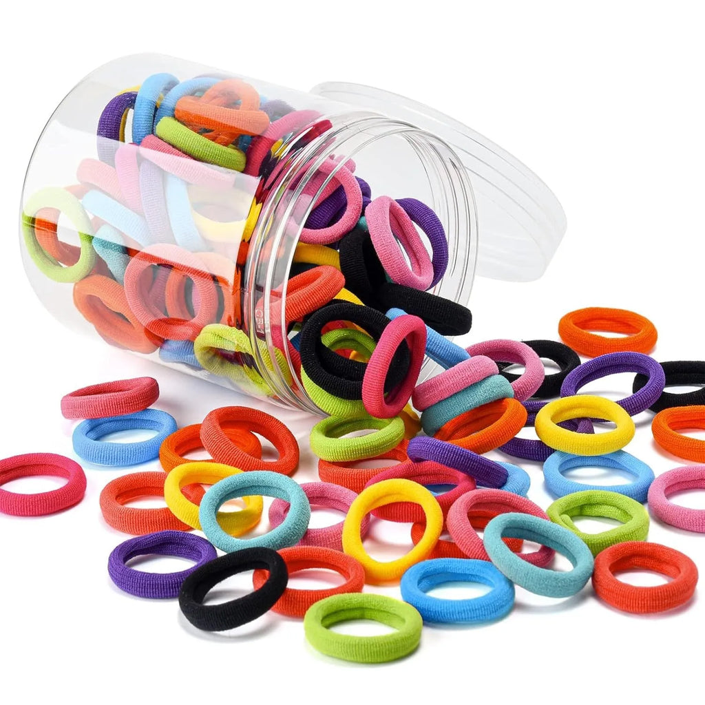 100 seamless cotton baby hair ties in 10 colours stored in a small glass jar.