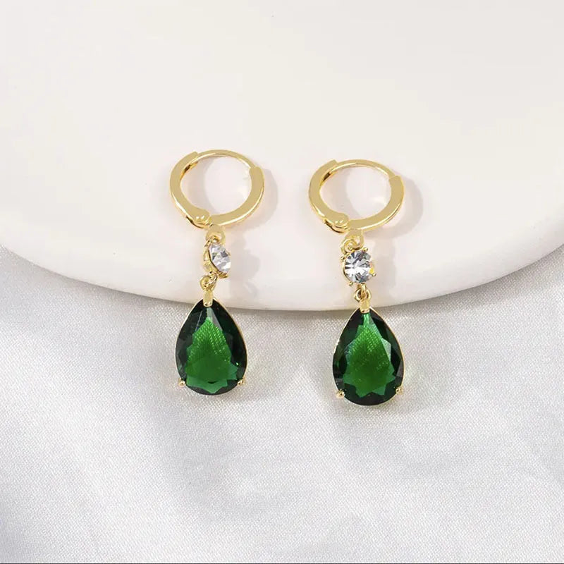 Emerald green geometric teardrop alloy earrings dangling from a model's ear.