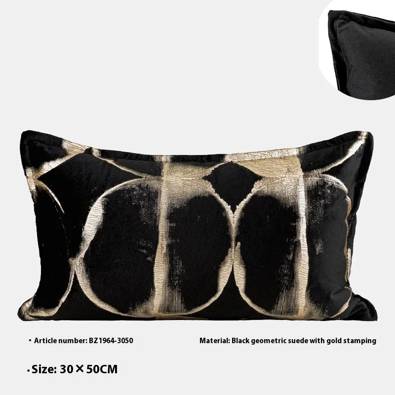 Abstract pattern black and gold decorative cushion pillow with removable cover on a grey sofa.