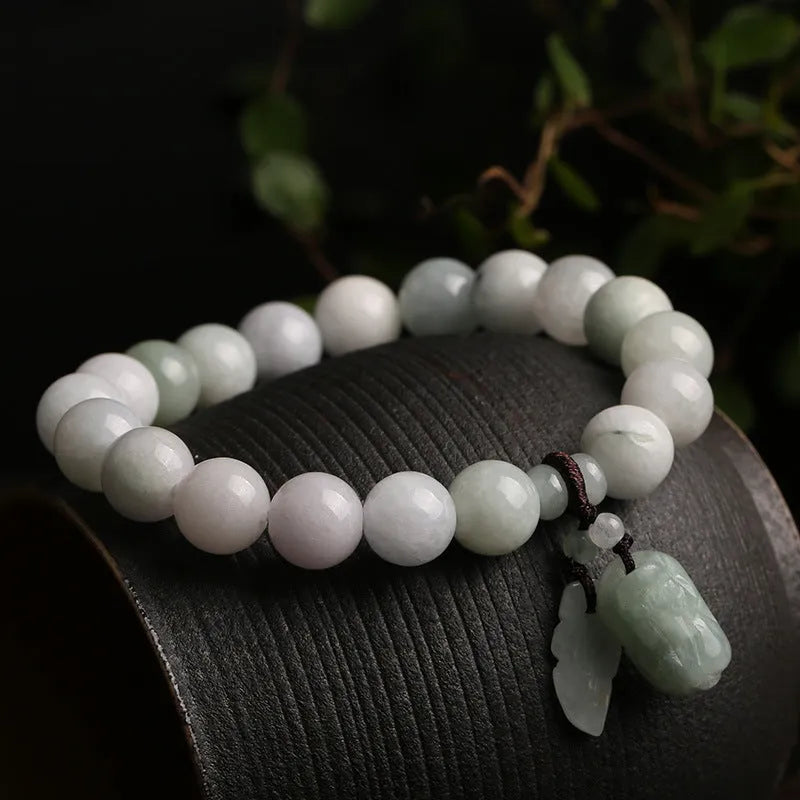 Jade hanging charm bracelet with geometric design and Buddhist symbolic pendant