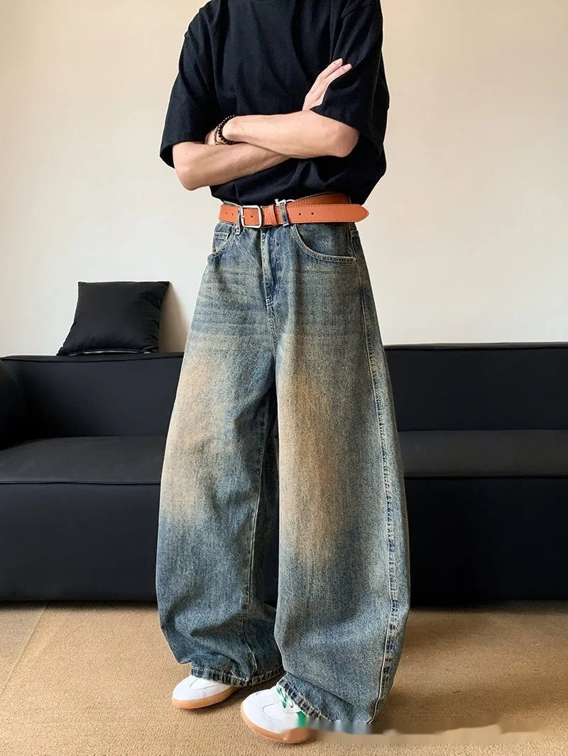 Man wearing retro blue distressed wide-leg denim jeans with a slimming fit and mid waist design.