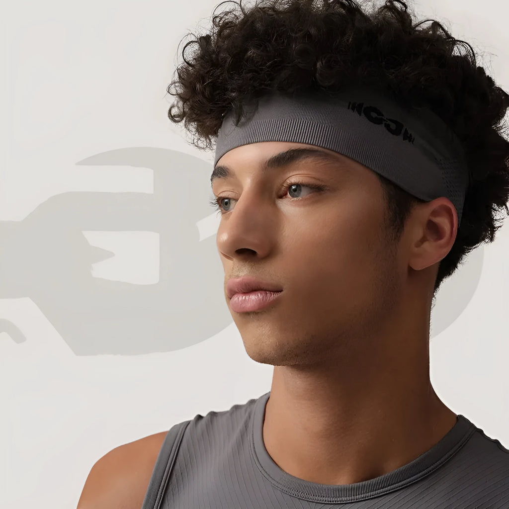Seamless knitted sports hair band in black, grey, and blue colours on a plain background.