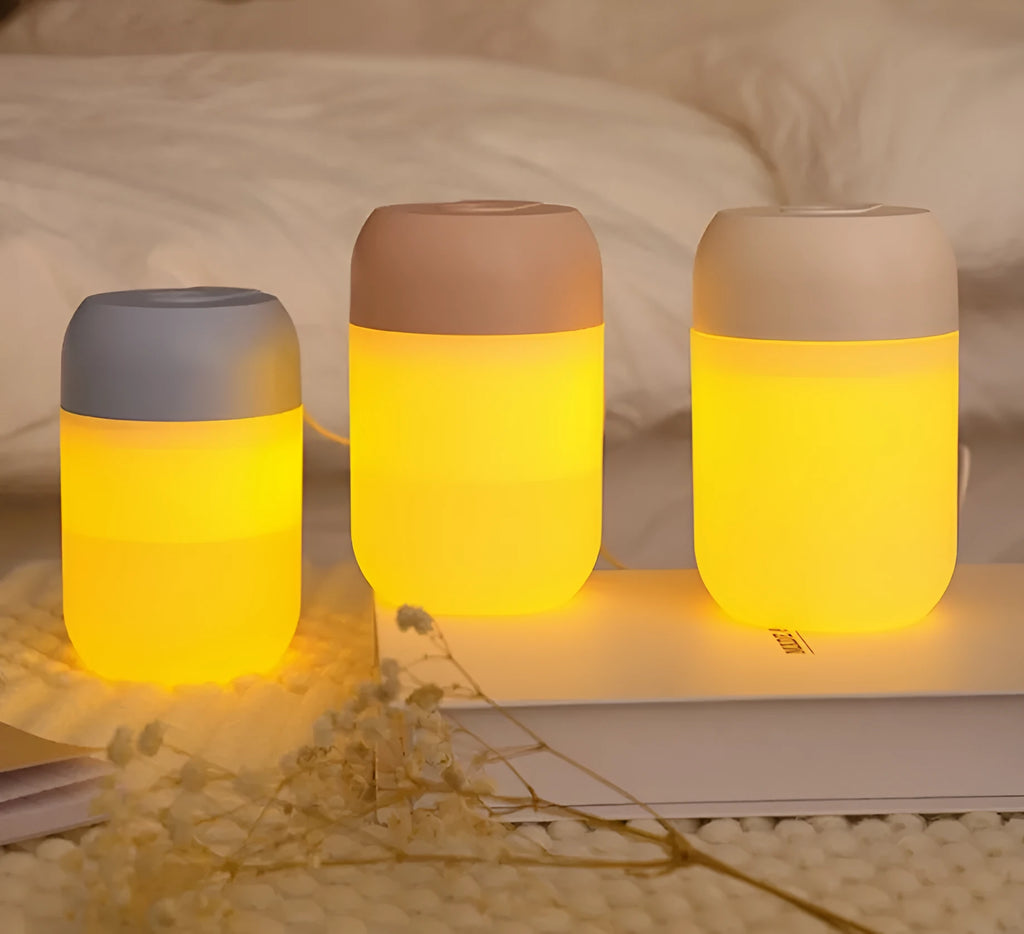 White cylindrical mini humidifier with USB cable on wooden desk