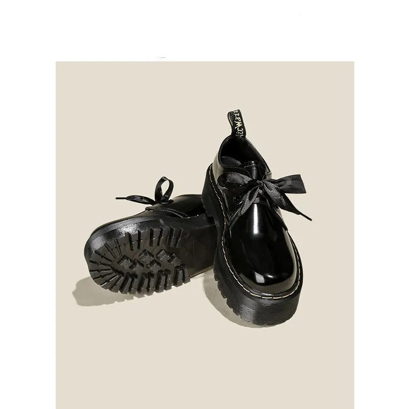 Women's black lace-up shoes with thick TPR sole, ribbon and cross strap details on superfine fibre upper.