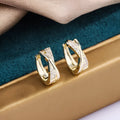 Geometric copper drop earrings with 14K yellow zircon treatment, showing structured shape and metallic finish