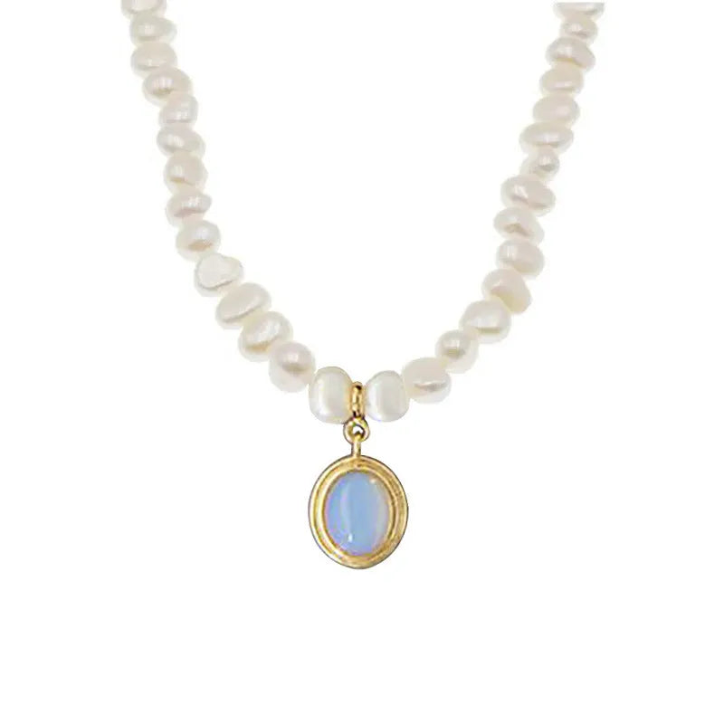 Round medal pearl necklace with geometric silver pendant and irregular pearls on a silver chain.