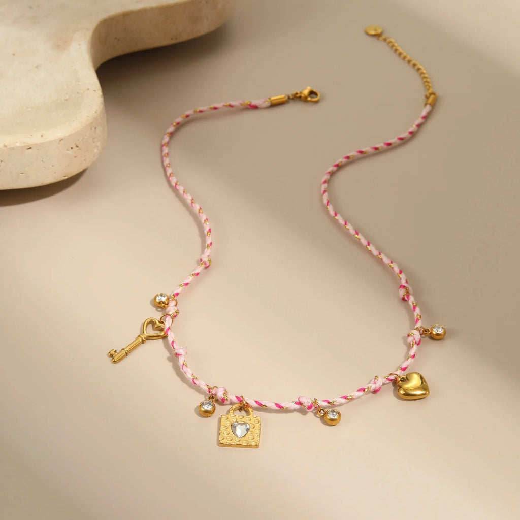 Close-up of a women's braided rope and titanium steel design necklace with a heart-shaped pendant on a stainless steel chain.