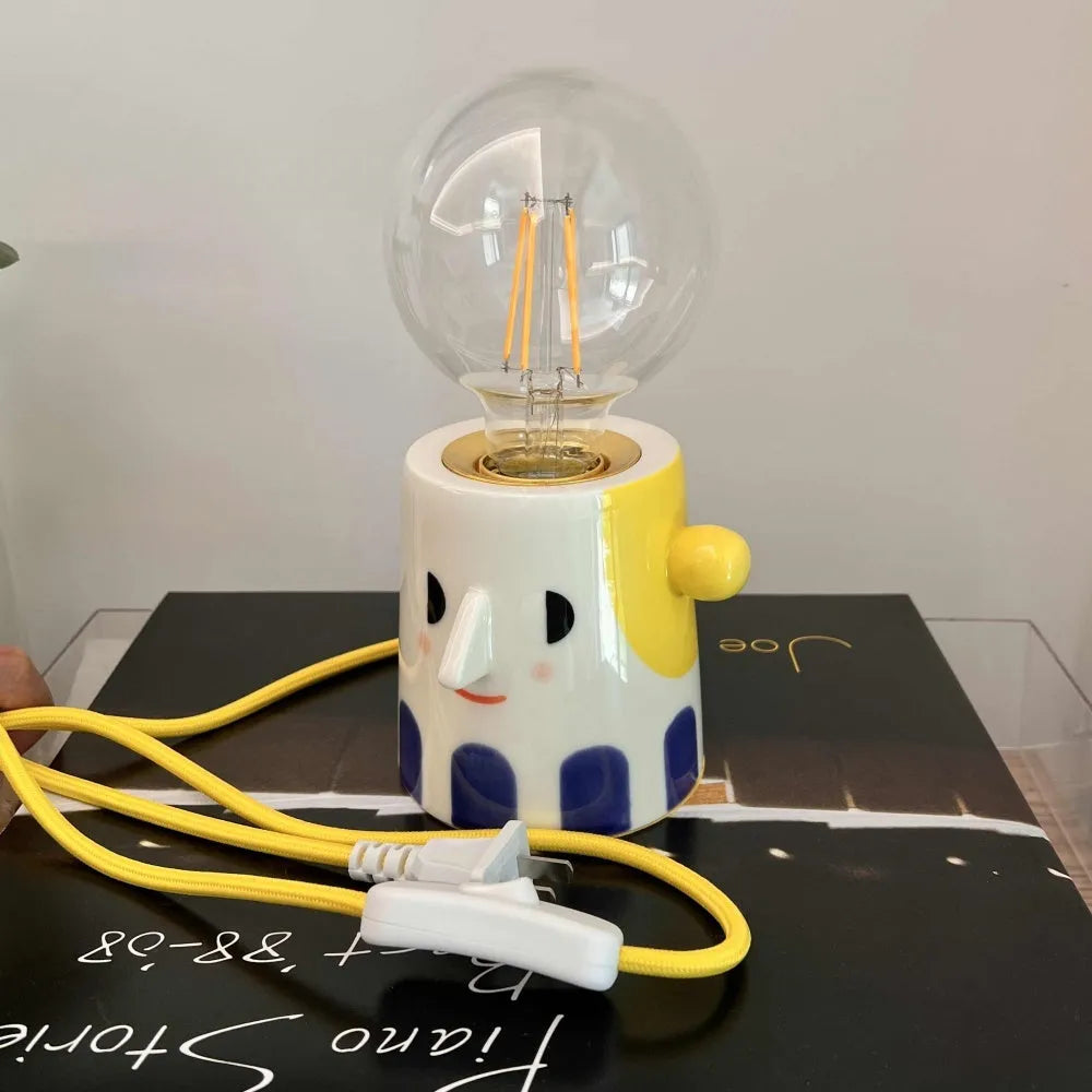Handmade ceramic bedside lamp with ball-shaped headlight design on wooden surface