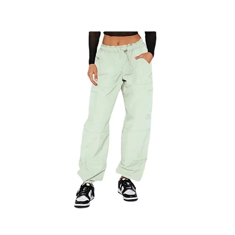 Man wearing beige multi-pocket cargo trousers with a loose straight-leg fit, showcasing the utility pockets.