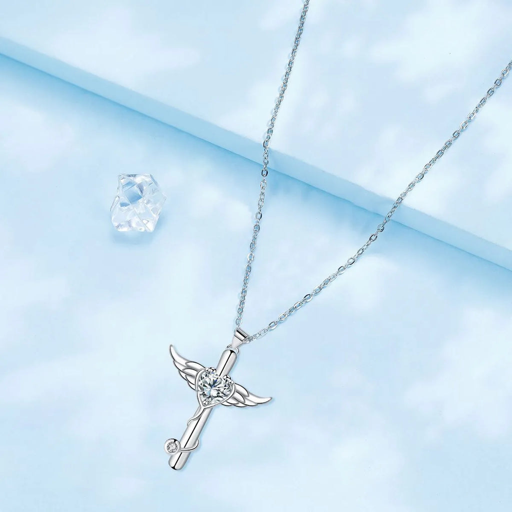 Close-up of a women's necklace featuring a combined cross and stethoscope pendant with wings detail in a red diamond finish.
