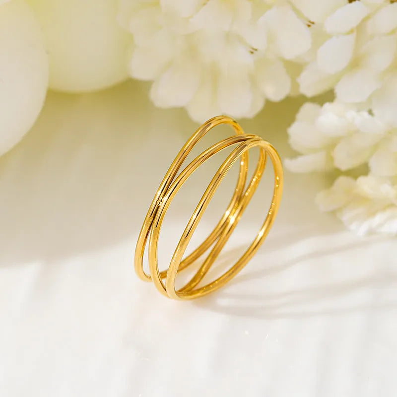 Gold titanium steel geometric ring with three-layer coil design shown from multiple angles