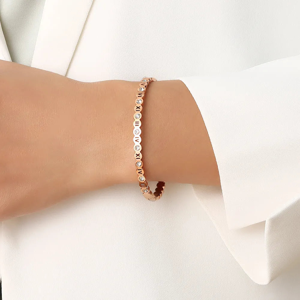 Adjustable titanium steel fashion bracelet with number charms in a choice of gold, rose gold, or steel colour.