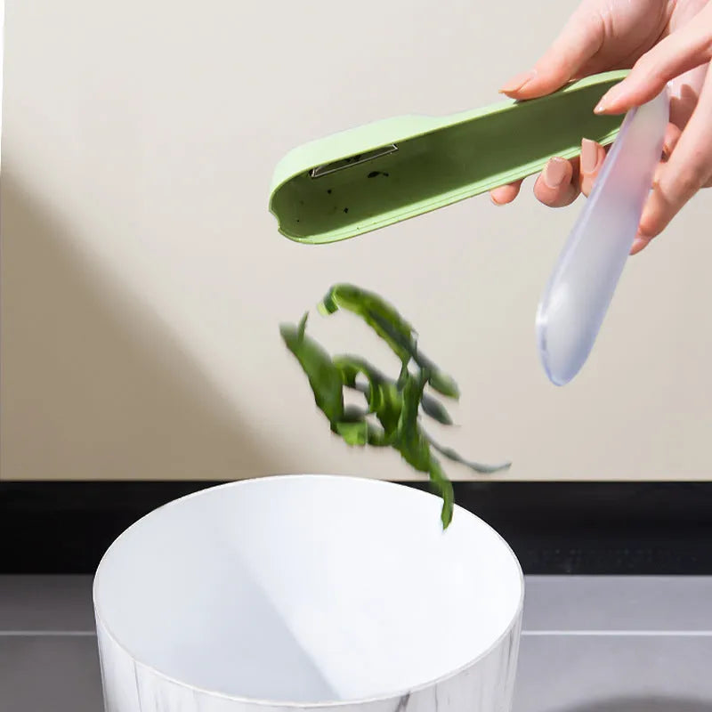 Dark green stainless steel vegetable peeler with integrated storage box and non-slip handle for kitchen use