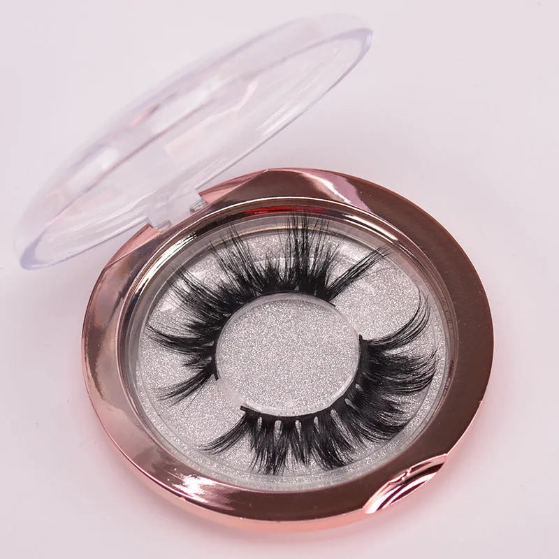 5D mink false eyelashes in natural black with curled ends, shown with double-headed glue brush and hair cap