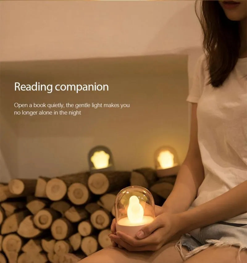 Pink cat paw shaped USB rechargeable night light with musical box function on wooden desktop