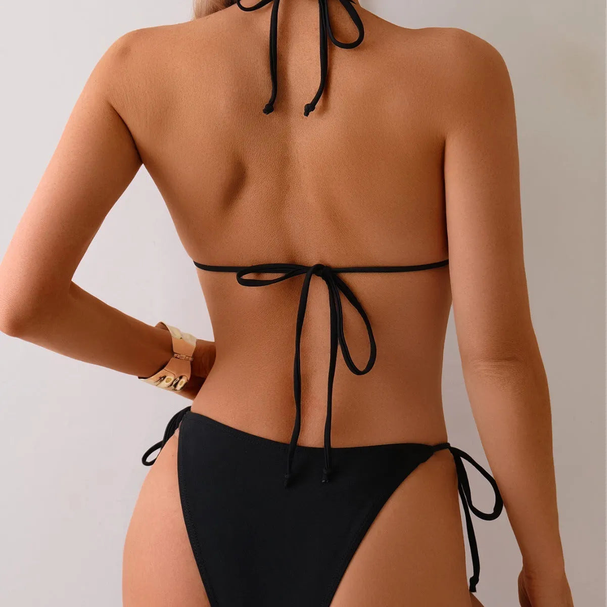Black women's two-piece bikini swimsuit with metal bead decoration and high-cut legs.