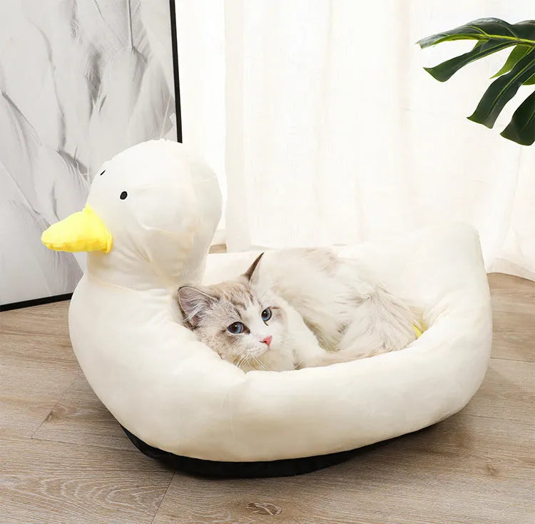 Blue duck-shaped fluffy pet bed for a small dog on a wooden floor.