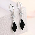 Silver vintage geometric diamond-shaped clip-on earrings on a plain background.