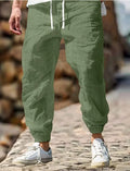 Men's straight-cut linen trousers with elastic waist in army green colour showing cotton fabric composition