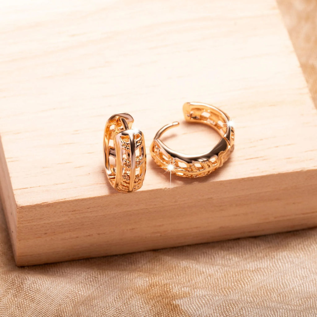 Rose gold coloured copper earrings with a hollowed leaf design and small heart detail.