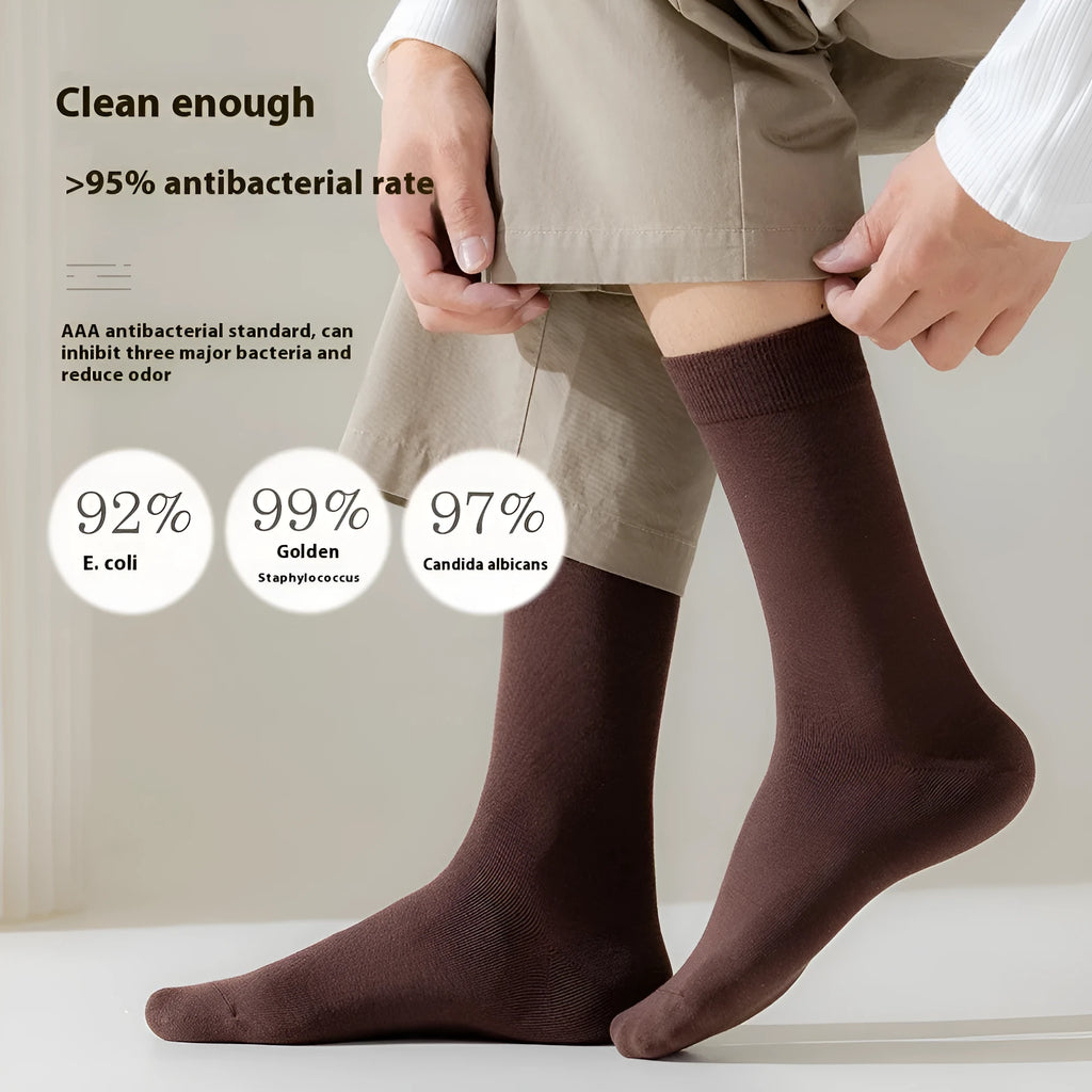 A pair of men's solid colour mid-calf socks made from combed cotton, shown in a light grey hue.
