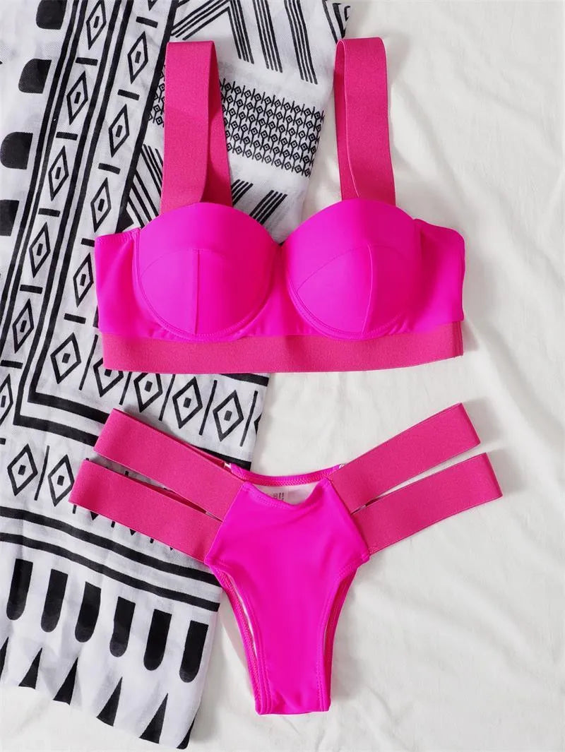 Women's rose red bikini with push-up support and separate pants laid flat.