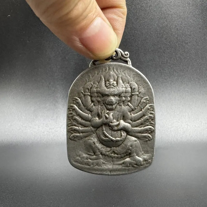 Close-up of an antique iron pendant depicting the Aryaacalanatha Yamantaka icon in a Chinese geometric style.