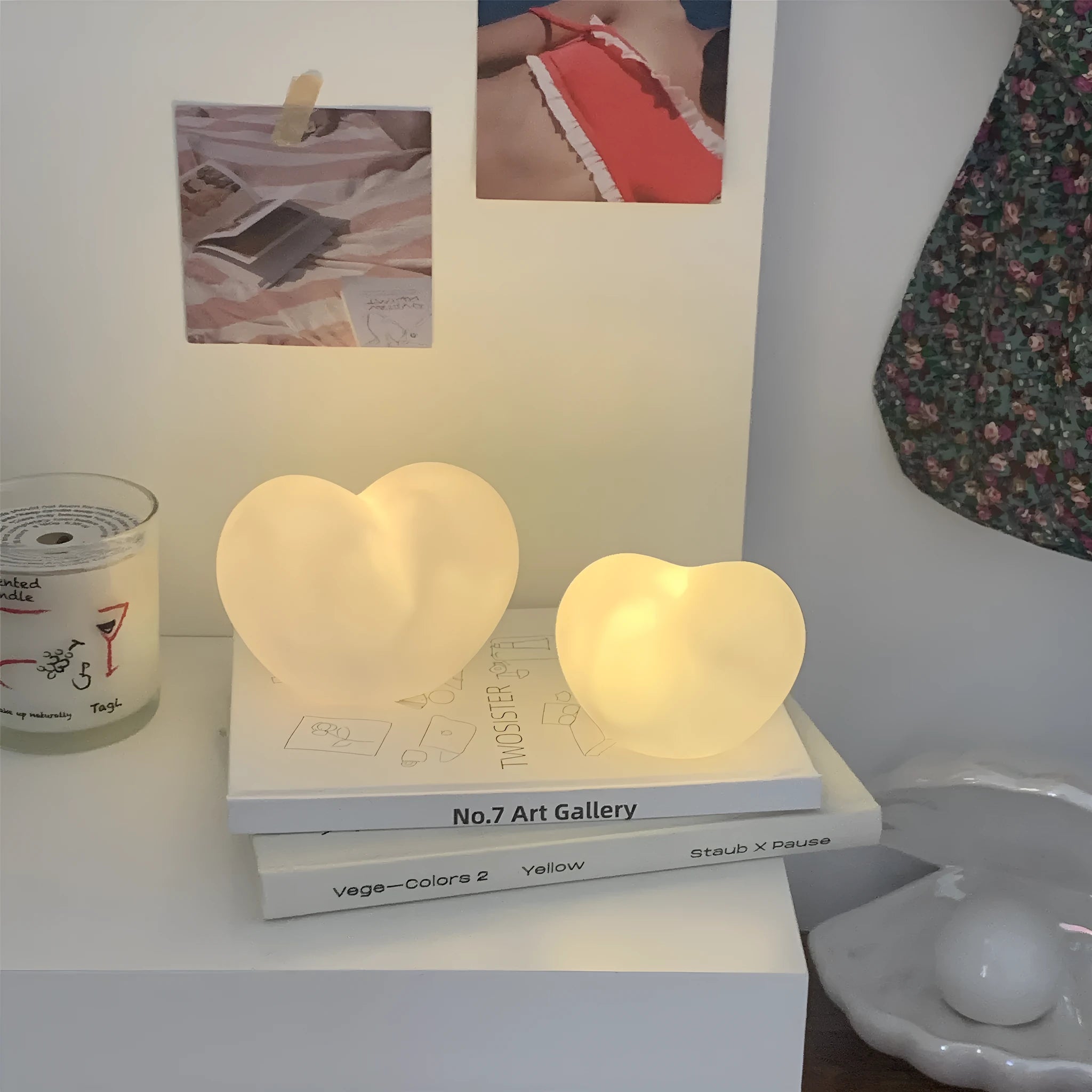 White and pink vinyl trumpet-shaped atmosphere lamps glowing with warm light on a dark surface.