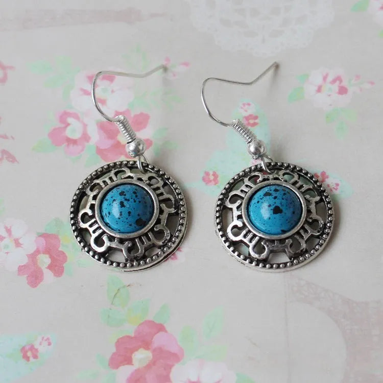 Handmade Miao silver earrings with turquoise flower disk design and ethnic totem patterns in red blue or black colour options