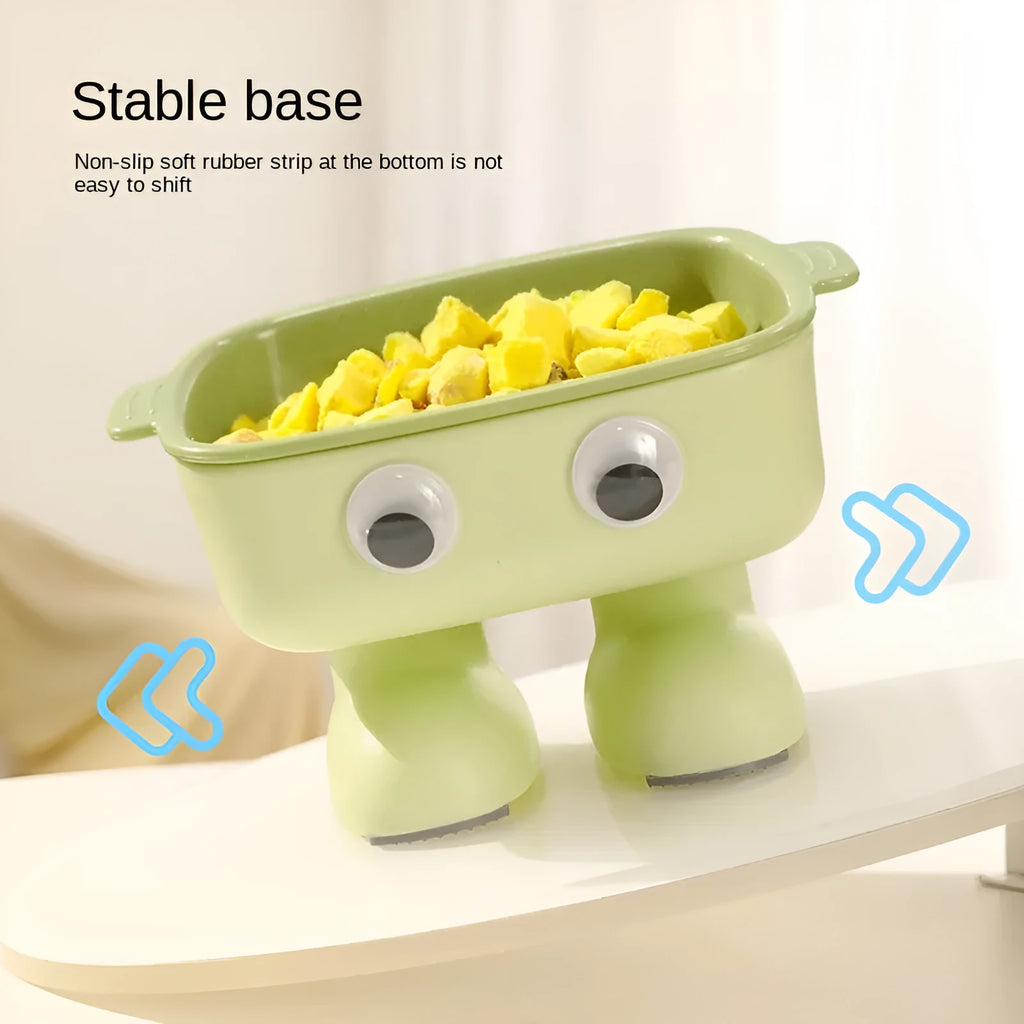 Green elevated cat bowl with 15-degree tilt, detachable inner dish, and cartoon robot design on a table.