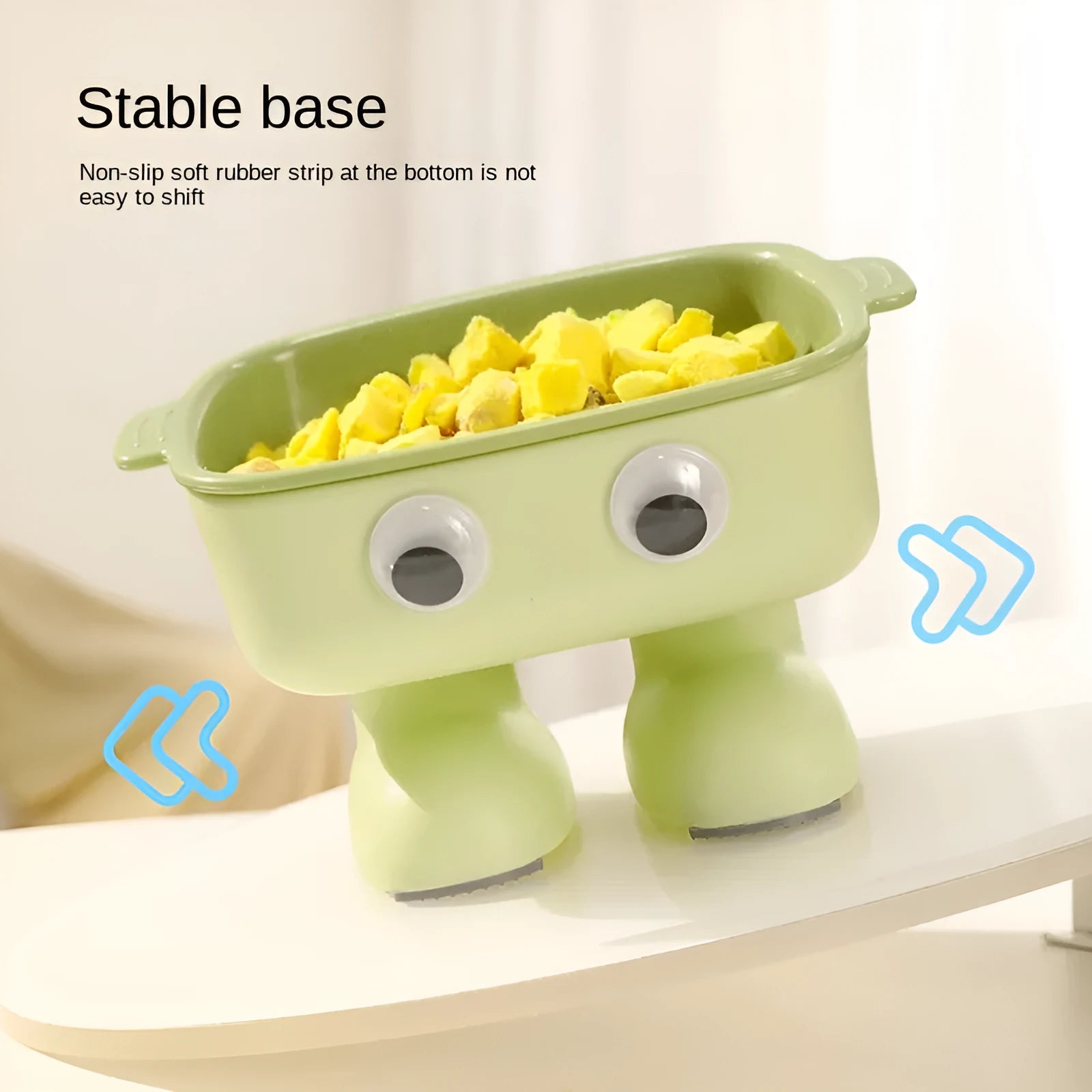 Green elevated cat bowl with 15-degree tilt, detachable inner dish, and cartoon robot design on a table.
