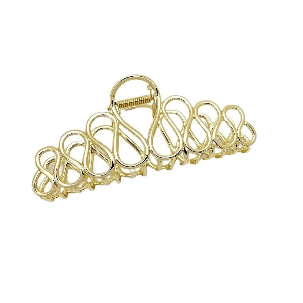 Large minimalist hair clip with tassel decoration in gold finish showing irregular shape design