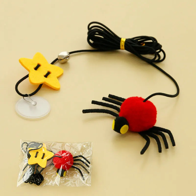 Cat hanging door toy with elastic rope, feather, bell and spider attachment on a white door.