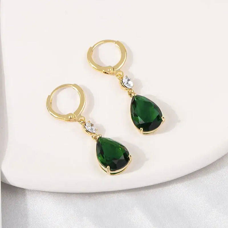 Emerald green geometric teardrop alloy earrings dangling from a model's ear.