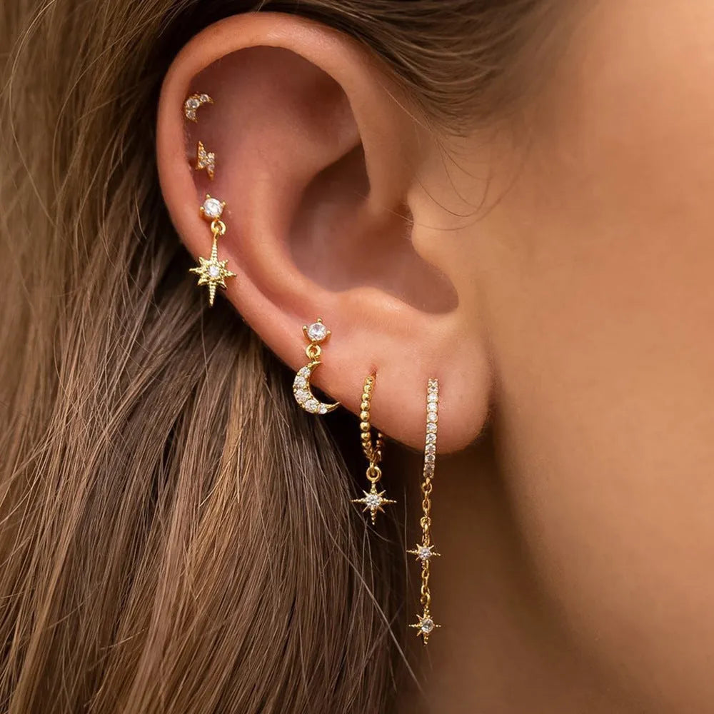 Gold-coloured chain tassel earrings with six dangling elements and zircon stud details on copper construction.