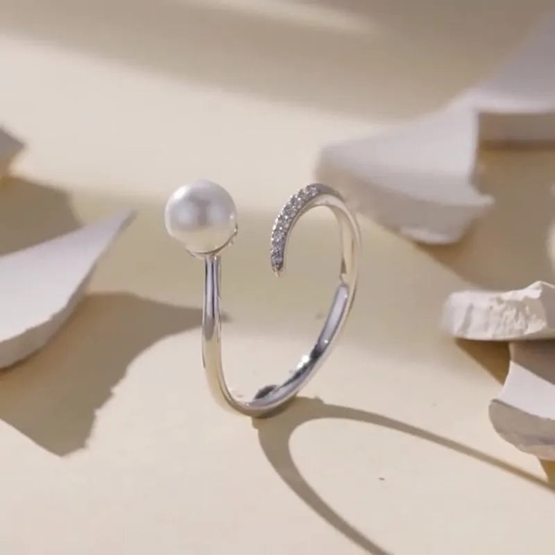 Shell pearls ring with S925 sterling silver construction and adjustable open loop design featuring natural pearl accent
