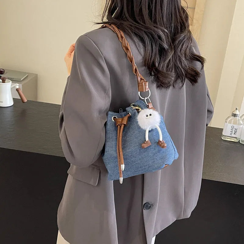 Blue one-shoulder cross body bucket bag with synthetic leather lining and medium-soft construction