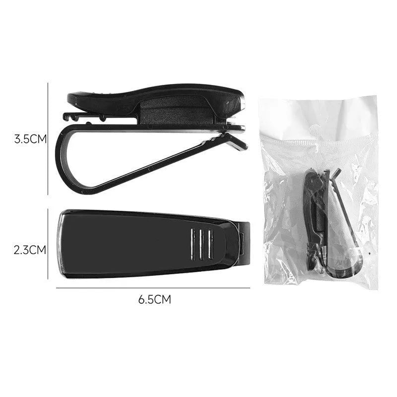 Black plastic car sun visor clip holding a pair of sunglasses and a parking ticket.