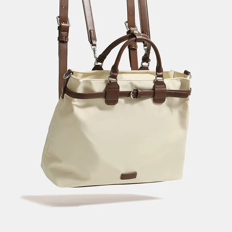 Women's nylon tote bag in creamy white with multiple internal pockets and three shoulder straps.