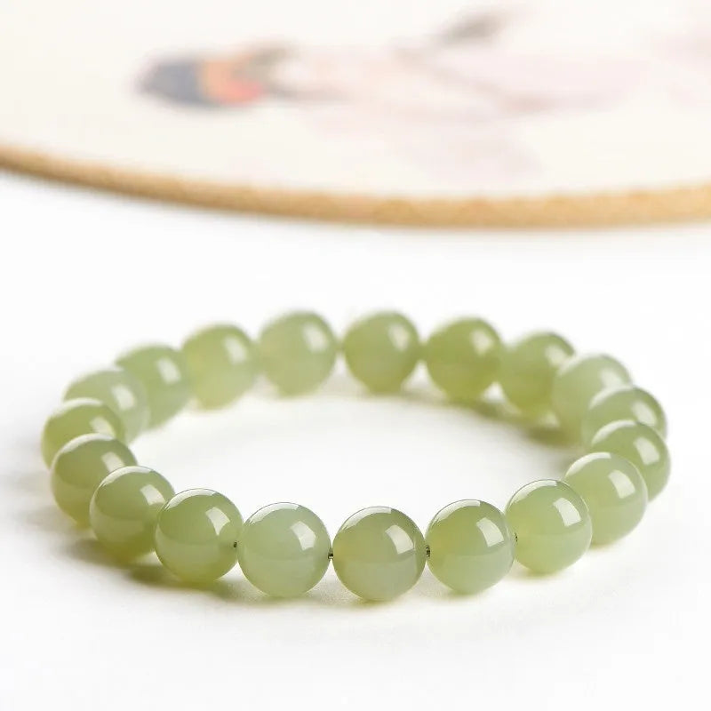Polished Hetian jade bead bracelet in ice clear colour on a wrist, showing bead detail.